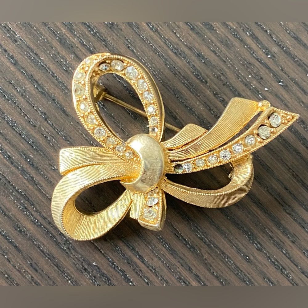 Gold coloured bow-style brooch lapel pin with gems